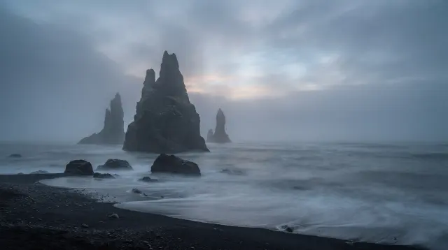 Basalt sea stacks in fog at dawn